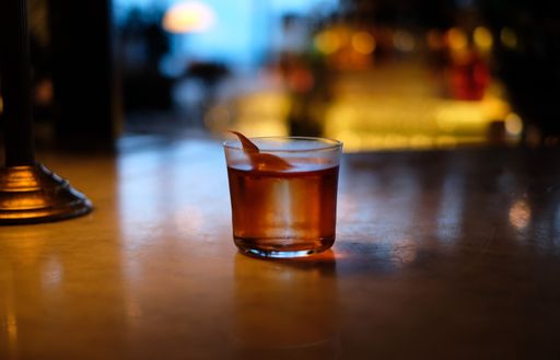 A closeup shot of a negroni cocktail on the wooden background