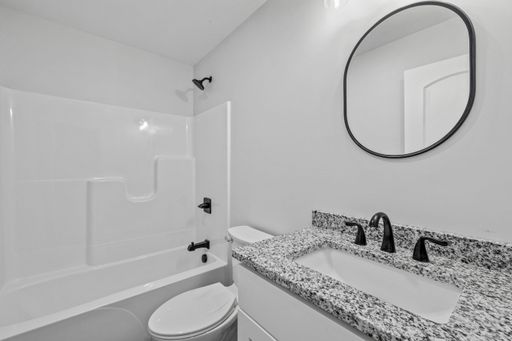 A beautiful modern newly renovated bathroom interior with granite sinks, mirrors, and white walls