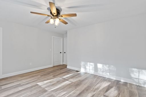 A modern ranch home interior design with an empty room with white walls and a ceiling fan with lights
