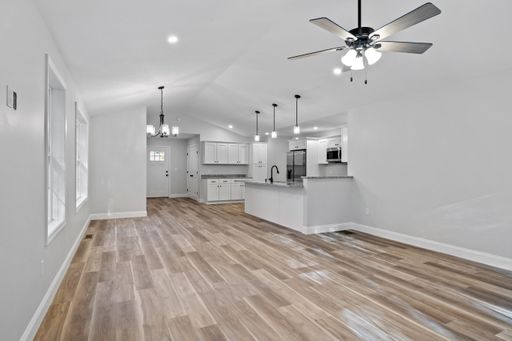 A beautiful newly renovated house corridor with hardwood floors and illuminated hanging lights