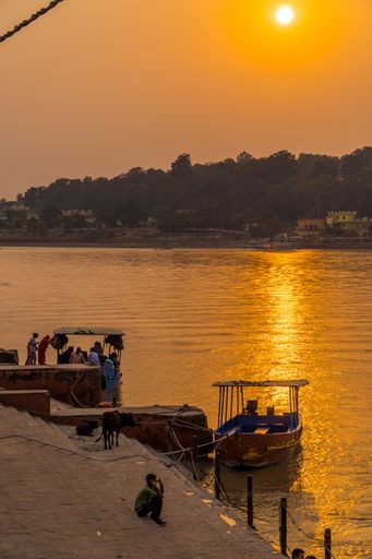 A vertical shot of old boats on the Ganges river during dramatic sunset