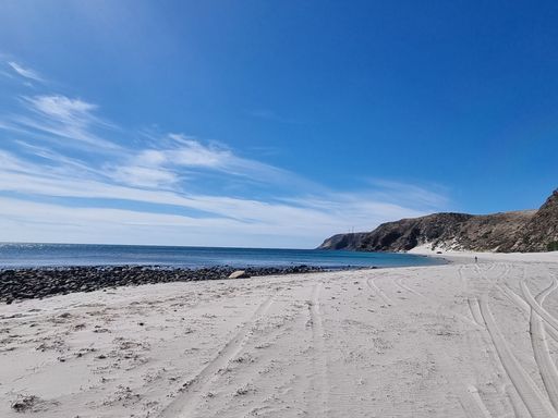 A sandy beach near the coastline captured from behind