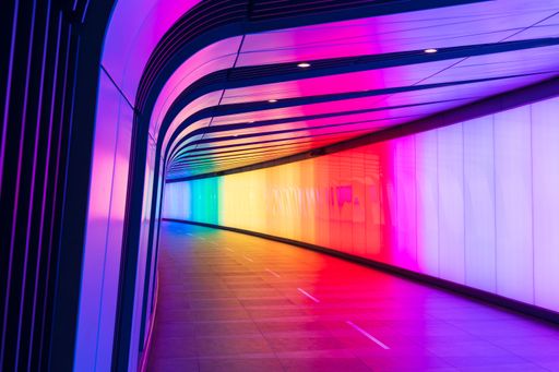 A modern futuristic open-road tunnel illuminated with colorful lights