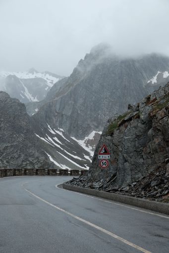 A vertical shot of rocky mountain pass on a foggy day