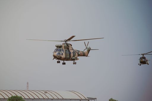 An air show in Pretoria, South Africa with French combat helicopters in a gloomy gray sky