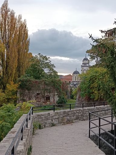 A brick pathway with a steel fence