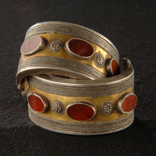 The antique bracelets with engraving and precious stones isolated on a black background