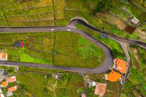 An aerial view of cliff road in autumn with the road cutting through having different turns