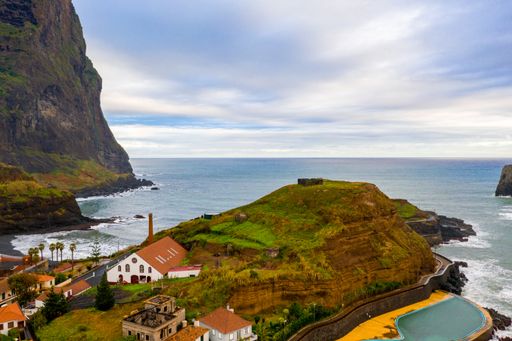 An aerial view of village of Porto Moniz with lava-rock pool, Madeira Island, under the cloudy sky