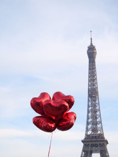 A vertical shot of  heart-shaped balloons in front of the Eiffel Tower ( Paris)