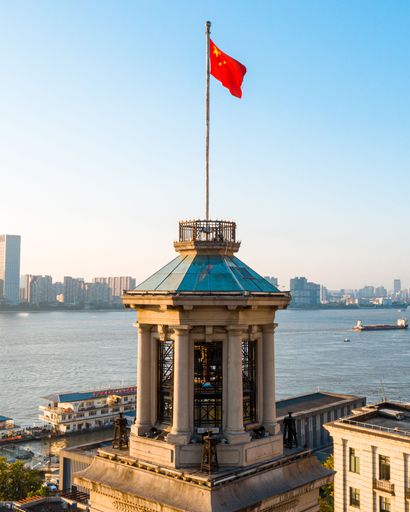 A vertical shot of Hankou Customs House Museum by the river in Wuhan under blue sky