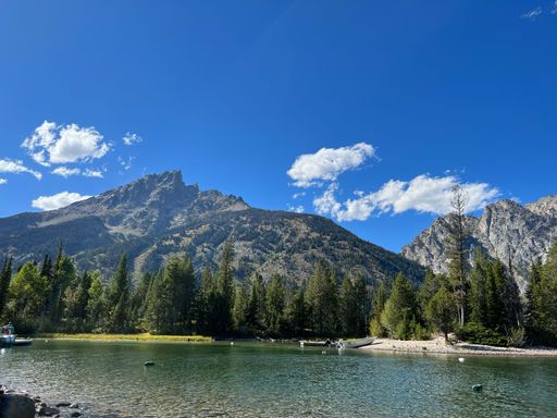 A beautiful shot of a lake surrounded by mountains under the clouds