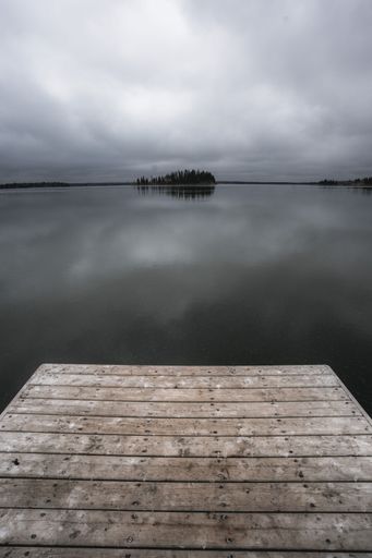 A vertical shot of a lake under a cloudy sky