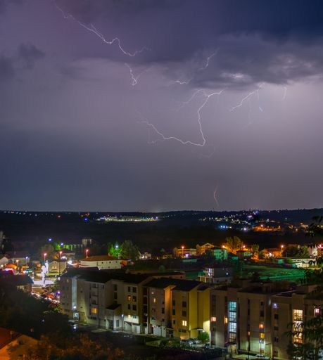 A Lightning sky over the city with apartment buildings at night