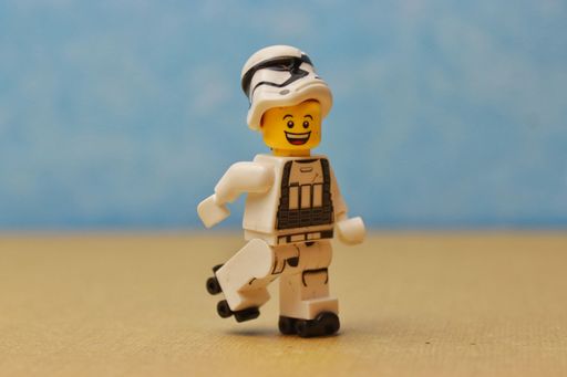 A smiling lego figurine with a stormtrooper helmet riding on roller skates
