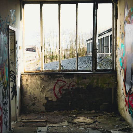 The interior of an abandoned factory with graffiti now used as a hangout spot