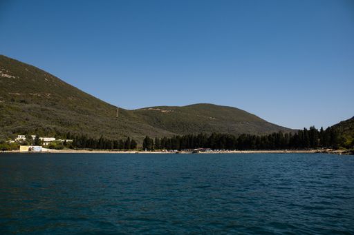 A beautiful shot of bright blue water near a coast with tree-covered hills