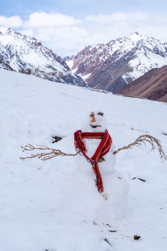 An image of a snow man on the mountain covered by snow.