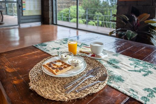 A cozy rustic breakfast in the cafe on wooden table with waffles, juice, and coffee