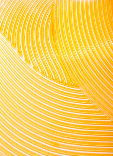 A vertical shot of a gold skincare slushed on a white background
