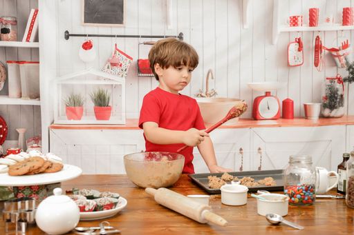 A young boy making cookies in the kitchen for Christmas