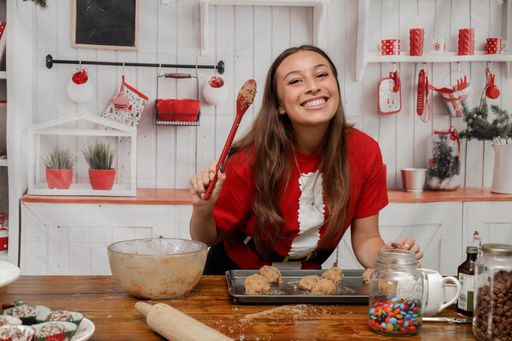 A young brunette girl posing and smiling while making cookies for Christmas