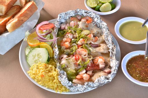 A tasty Mexican food with Shrimp and seafood with sauces on wooden surface