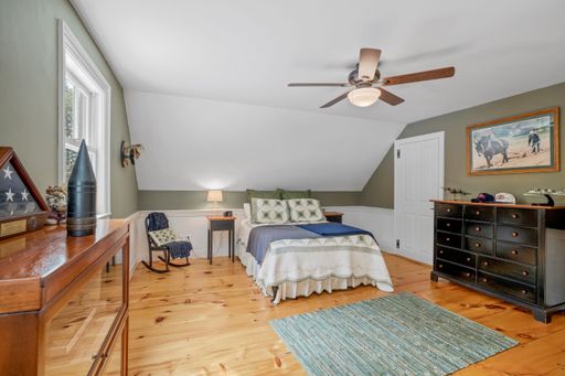 A vintage decoration of a comfortable bedroom with wooden furniture and a ceiling fan