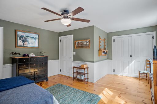 A vintage decoration of a comfortable bedroom with wooden furniture and a ceiling fan