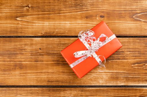 A red Christmas gift box on a wooden table