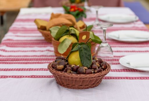 A selective focus of quince on top of a chestnut basket on a party table