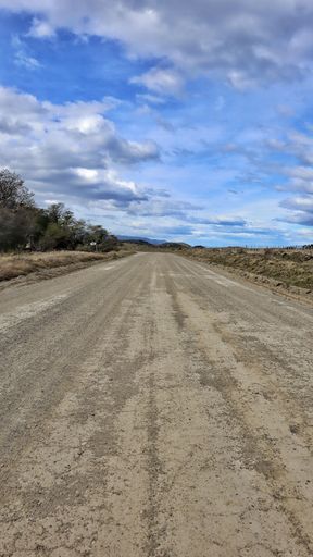 An empty rural road against the backdrop of a cloudy sky.