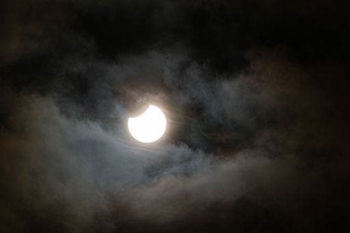 Partial solar eclipse behind turbulent clouds
