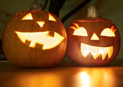 A closeup of jack-o'-lanterns on a wooden floor