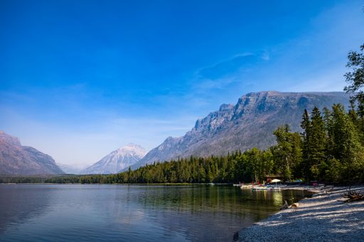 A scenic view of a lake shore during daytime in Glacier National Park, Montana