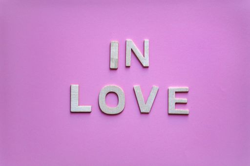 A top view of in love word on a pink background - the concept of Valentine's day