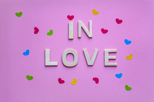 A top view of in love words and hearts on a pink background - the concept of Valentine's day