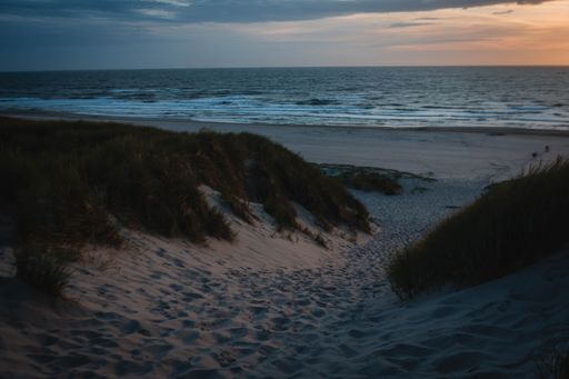 A beautiful sunset on the beach with an orange sky in the background