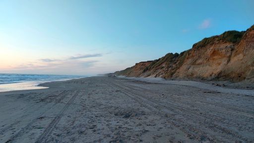 The sea waves splash over the sandy shore at sunset perfect for wallpapers