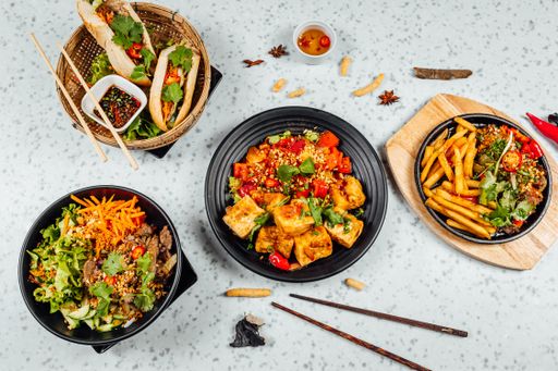 A closeup shot of delicious Vietnamese food including Pho ga, noodles, spring rolls on white background