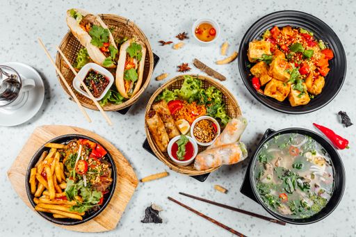 A closeup shot of delicious Vietnamese food including Pho ga, noodles, spring rolls on white background