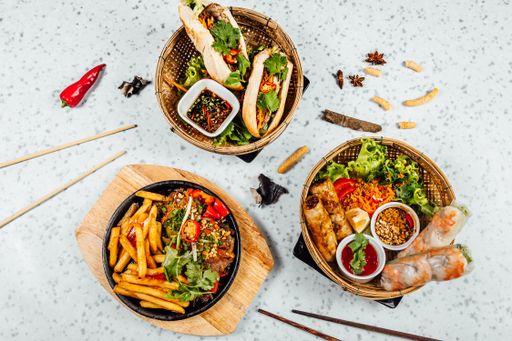A closeup shot of delicious Vietnamese food including Pho ga, noodles, spring rolls on white background