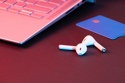 A closeup of a laptop near wireless earphones