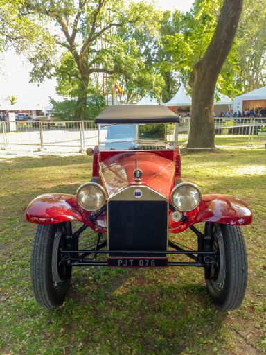 Vintage red 1926 Lancia Lambda VII Series Torpedo in a park. Nature, grass, trees. Autoclasica 2022 classic car show. Front view.