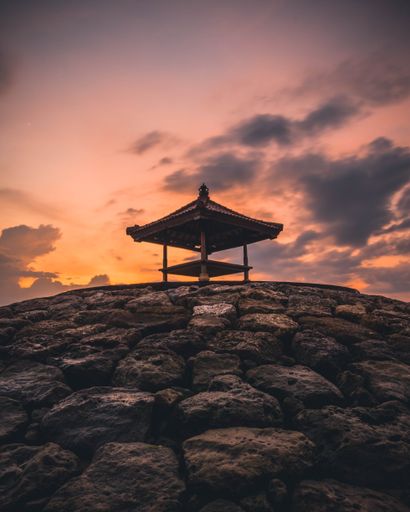 A vertical closeup of an arbor on the rocky platform in Sanur, Bali at sunset