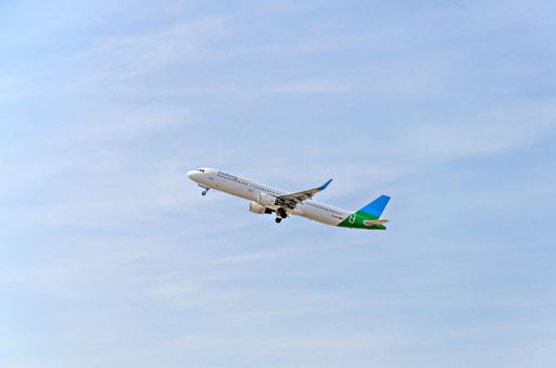 The Vueling Airbus A321 airplane in flight against a blue cloudy sky taking off from the airport