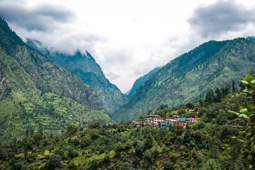 The view of a small town surrounded by green mountains. Kasol, India.