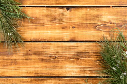 A Christmas background with pine branches on wooden board