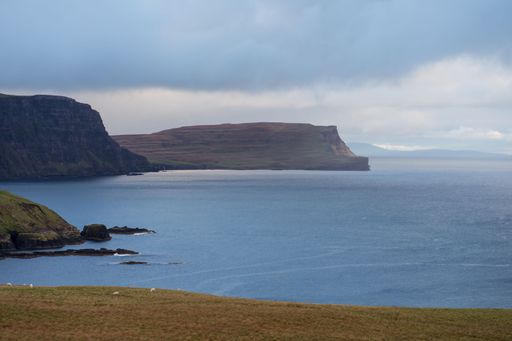 A rocky island near the ocean on a cloudy day