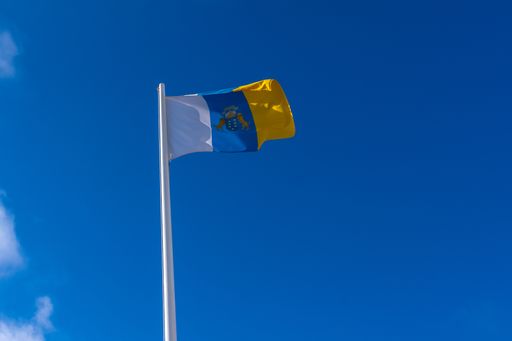A low angle shot of the flag of the Canary Islands on a pole during the daytime